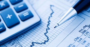 Close-up of a Calculator and Pen on a Financial Newspaper.  Blue-toned.